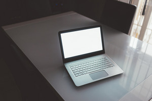 Laptop with a blank screen placed on a desk, representing modern technology